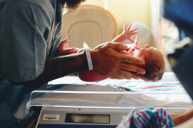 nurse holding newborn baby in hospital