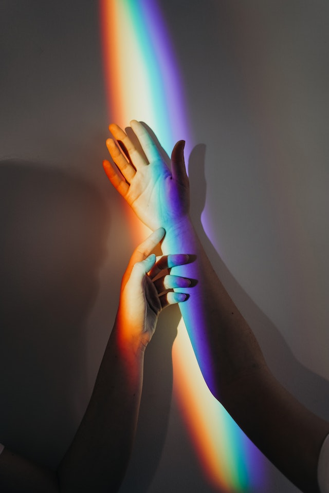 hands in front of a rainbow
