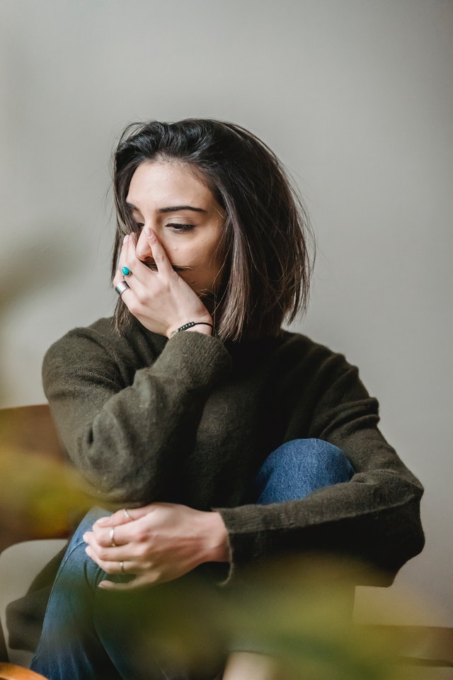 upset woman with her hand covering her face